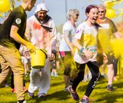 Child and group of adults running at the Rainbow Run.