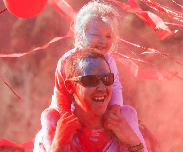 Child on fathers shoulders at Rainbow Run.